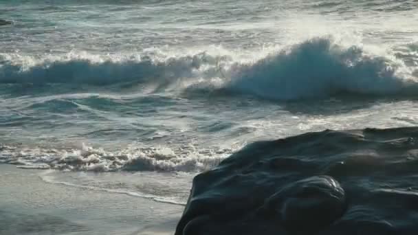 海は深い青 波は夏の海岸の砂浜のビーチで太陽の光を洗っています — ストック動画
