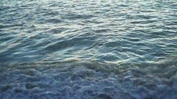 海は深い青 波は夏の海岸の砂浜のビーチで太陽の光を洗っています — ストック動画