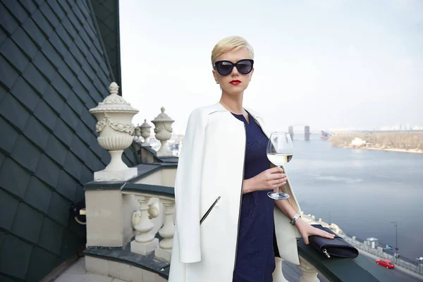 Beautiful business woman date meeting hotel balcony nice view on the river date drink wine glass wear white jacket dress handbag sunglasses perfect lifestyle.