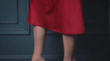 Güzel esmer kadın Bayan ipek kırmızı elbise akşam makyaj mavi bir duvara bir lüks hayat göz alıcı model stil moda takı ihale cilt genç çekici seksi Bayan içinde güneşlenmek için eğilir.