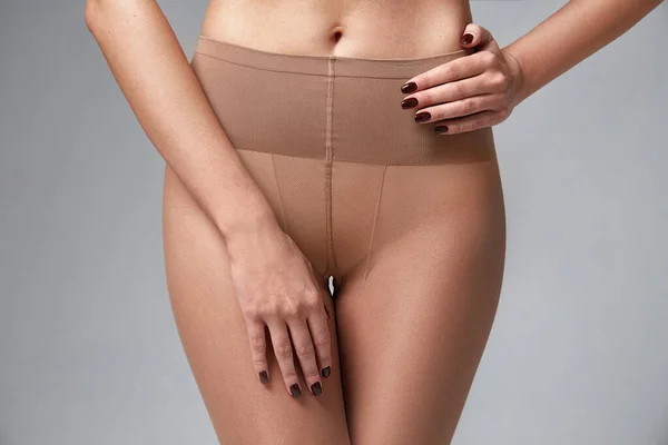 女性の体の一部完璧な形状の腰の足の皮膚日焼けの着用ストッキング ナイロン パンストランジェリーホーススタジオショット上の白の背景 — ストック写真