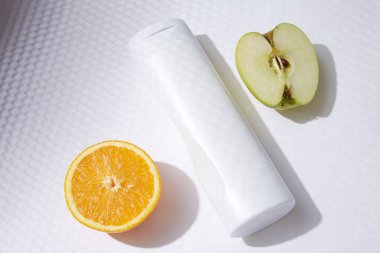 Beyaz şişe flakon kozmetik güzellik ürünü cilt bakımı yüz kremi ve vücut losyonu, duş jeli doğal organik kozmetik elma portakalı meyvesi.
