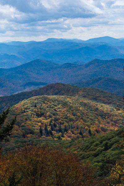 Світло виділяє нижню гору, покриту осінніми кольорами — стокове фото