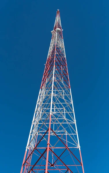 Tittar upp på mobilmast på blå himmel — Stockfoto