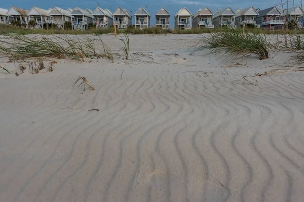 Valuri de nisip în fața caselor uniforme de plajă — Fotografie, imagine de stoc