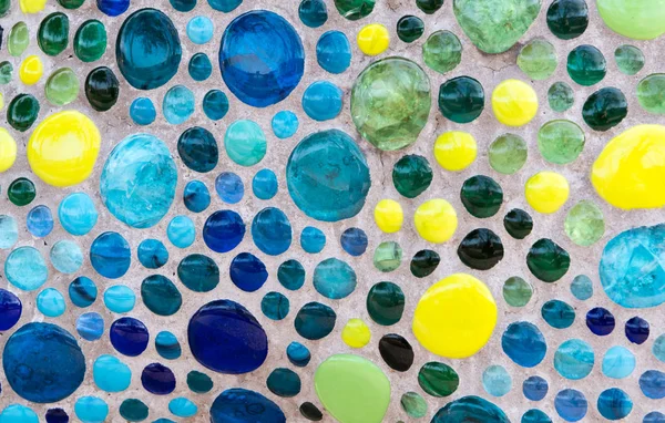 Blauwe en gele glazen kralen in beton — Stockfoto
