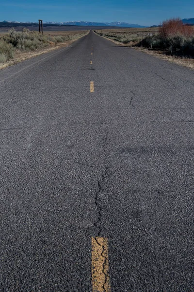Op zoek naar beneden lange Desert Road — Stockfoto