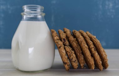 Süt kavanoz karşı yaslanmış altı yulaf ezmesi kuru üzüm kurabiyeleri