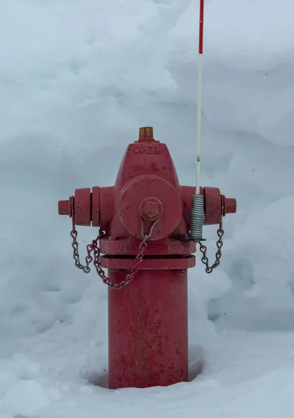 Hidrante de fuego rojo en nieve profunda — Foto de Stock