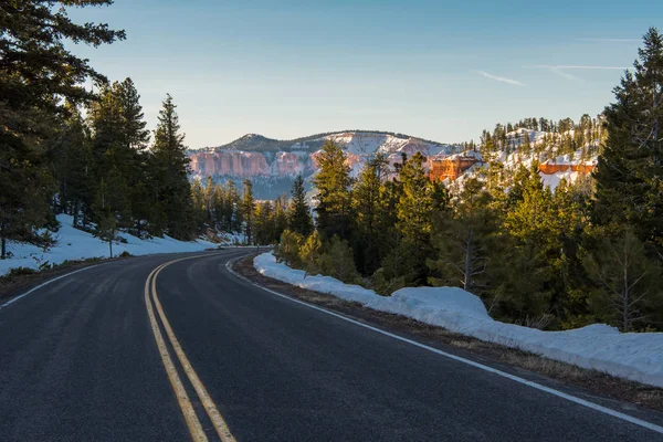 Zasněžené horské silnici s jasně oranžové skály — Stock fotografie