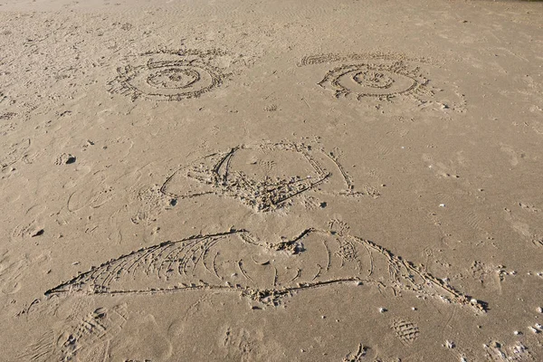 Visage sculpté dans le sable — Photo