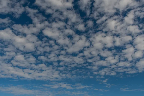 Gezwollen gebied van wolken op blauwe hemel — Stockfoto