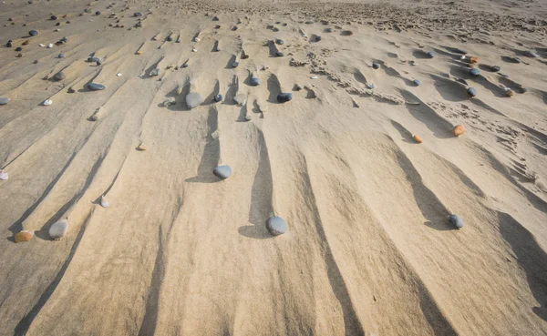Камни и дрейфы в песке — стоковое фото