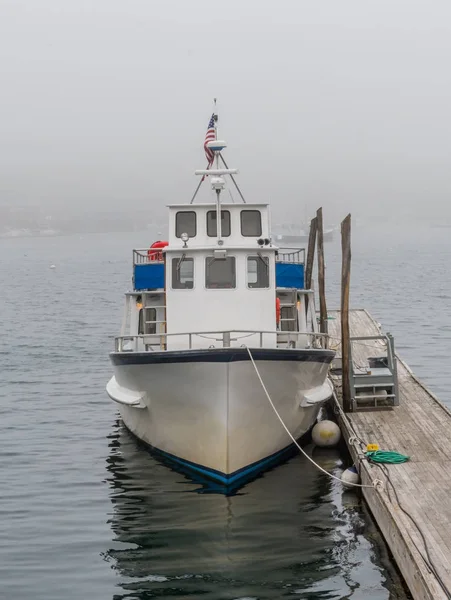 Weißes Ausflugsboot in nebliger Bucht festgemacht — Stockfoto