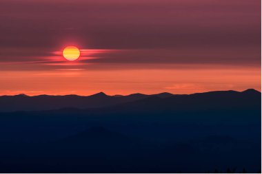 Güneş parlıyor günbatımı bulutlara aracılığıyla