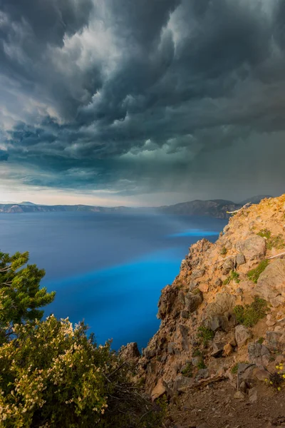 La luz del sol irrumpe a través de nubes de tormenta sobre el lago del cráter —  Fotos de Stock