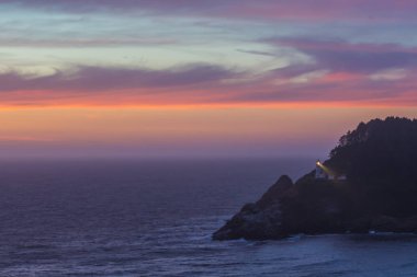 Bulutlar günbatımı Heceta başının üzerine yansıtır.