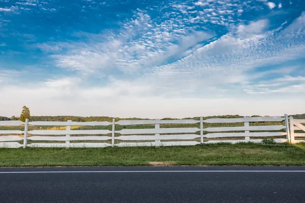 Bílý plot podél vedlejší silnice — Stock fotografie