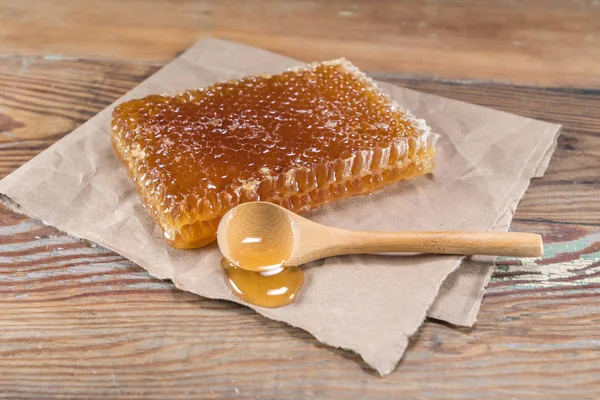 Bloco de favo de mel e colher de madeira — Fotografia de Stock