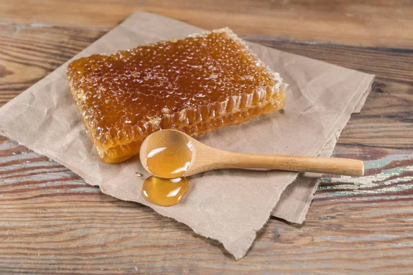Rechteck-Honigwabe und Holzlöffel Honig — Stockfoto