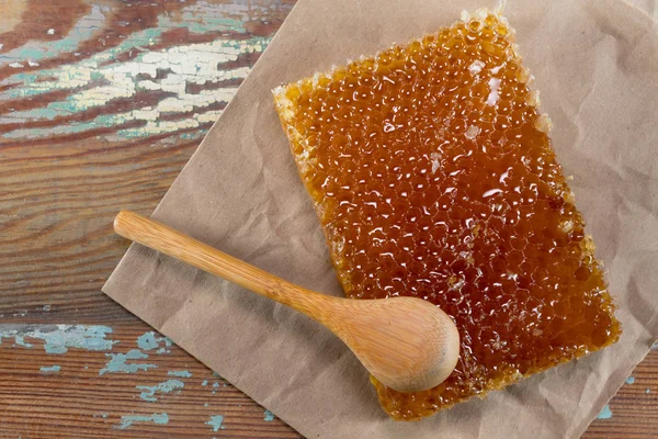 Cucchiaio di legno si appoggia sul blocco pettine miele — Foto Stock