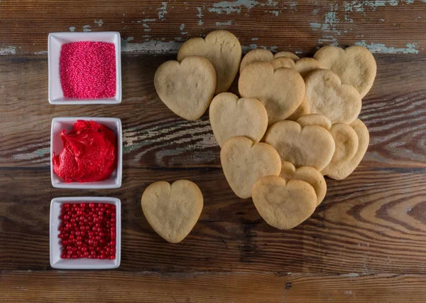 Pile of Heart Cookies with Bowls of Decorations