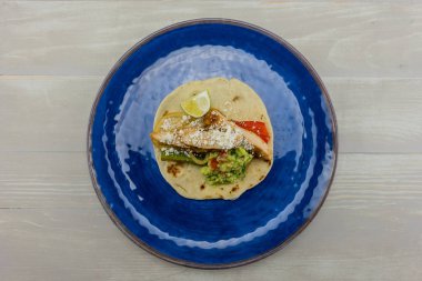 Mavi plaka üzerinde Guacamole ile tek Fajita