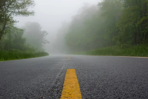 Líneas rayadas en un camino en la niebla — Foto de Stock