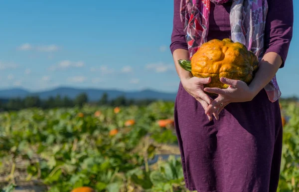 Carrying an Orange Bumpy Pumpkin — Stock Photo, Image