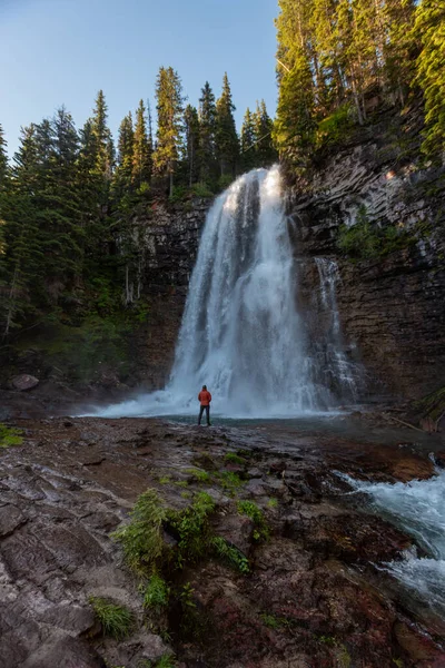 Homme en manteau orange se tient en dessous de Virginia Falls — Photo