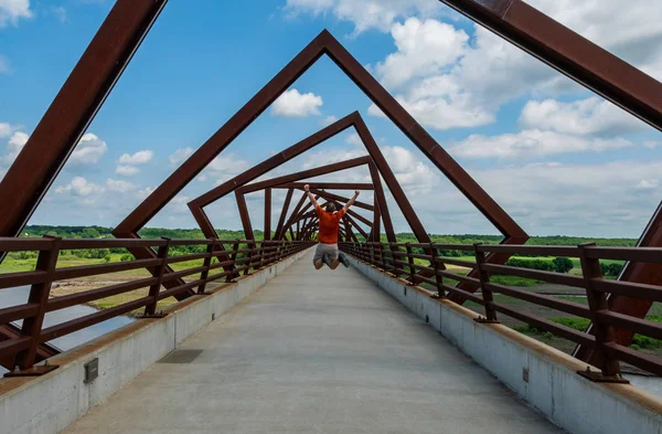 Muž skáče vysoko pod kroutícím se mostem — Stock fotografie