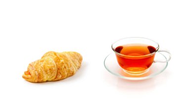 Beyaz arka planda bir fincan çay ve kruvasan.