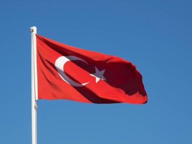 Mavi gökyüzünde dalgalanan Türk bayrağı.