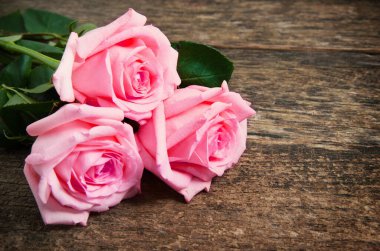 Ahşap masanın üzerinde pembe güller