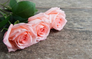 Ahşap masanın üzerinde pembe güller