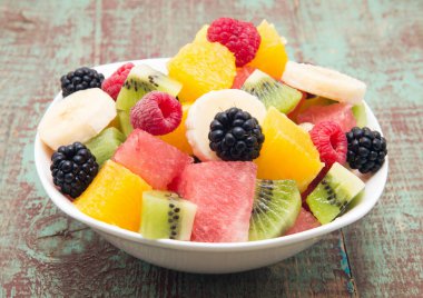 Tahta arka planda taze sağlıklı meyve salatası