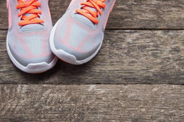 Ahşap arka planı olan spor ayakkabıları.