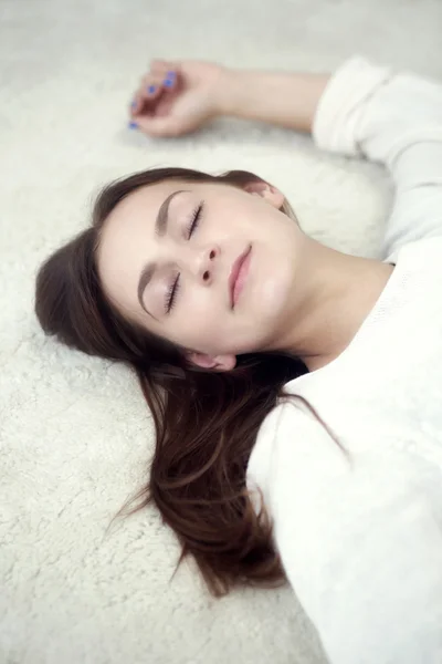 Porträtt av ung kvinna sover på mattan — Stockfoto