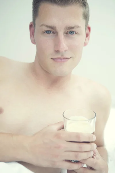 Portret van blonde man in bed met glas koffie — Stockfoto