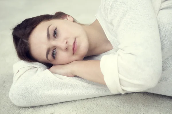 Porträt einer brünetten Frau auf Teppich liegend — Stockfoto