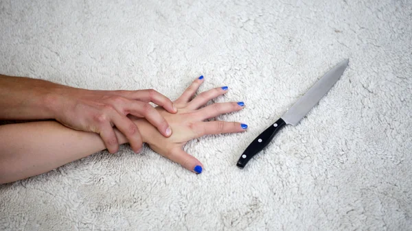 Closeup of woman grabbing a knife while being attacked by man — Stock Photo, Image