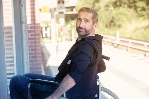 Man sitting in wheel chair at train station — Φωτογραφία Αρχείου