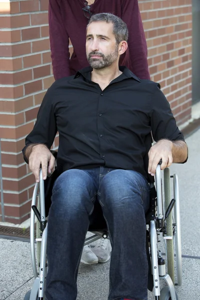 Hombre en silla de ruedas fuera buscando confiado —  Fotos de Stock