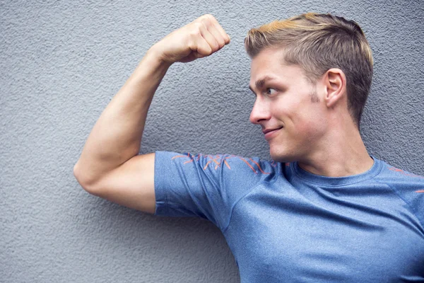 Porträt eines blonden Sportlers, der seine Muskeln zeigt — Stockfoto