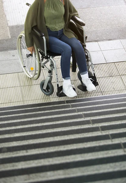 Mujer en silla de ruedas delante de las escaleras — Foto de Stock