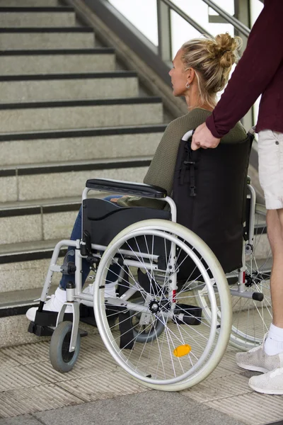 Mujer en silla de ruedas delante de las escaleras —  Fotos de Stock