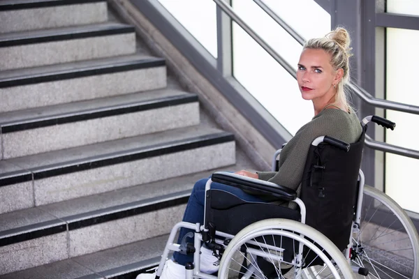 Woman in a wheelchair in front of stairs — Stock Photo, Image