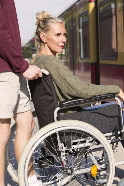 Kobieta na wózku inwalidzkim na stacji kolejowej — Zdjęcie stockowe