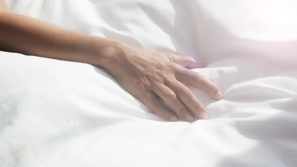 Closeup of female arm on white bedsheets — Stock Photo, Image