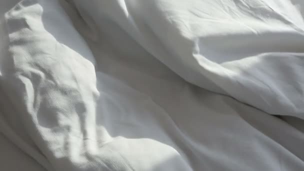 Weiße Decke auf dem Bett wird langsam aus dem Rahmen gezogen — Stockvideo